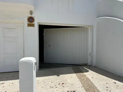 a white garage with a door in a room at La Barrosa in Novo Sancti Petri