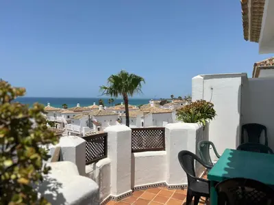 a balcony with a table and chairs and the ocean at La Barrosa in Novo Sancti Petri
