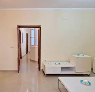 a living room with white walls and a table at Roy's Cadiz Inn in Cádiz