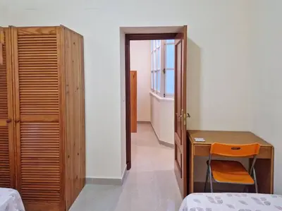 a bedroom with a desk and a bed and a window at Roy's Cadiz Inn in Cádiz