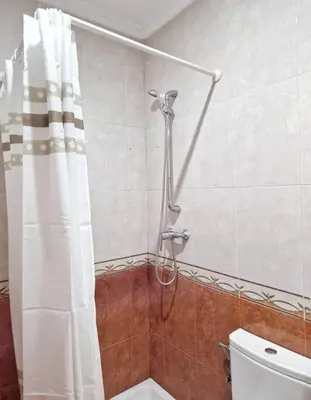 a shower curtain in a bathroom with a toilet at Roy's Cadiz Inn in Cádiz