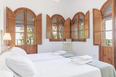 two beds in a room with windows at Apartamento con terraza en Playa de Regla. 6. in Chipiona
