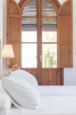 a bedroom with white pillows on a bed with a window at Apartamento con terraza en Playa de Regla. 6. in Chipiona