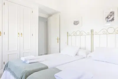 two beds in a white room with white walls at Apartamento con terraza en Playa de Regla. 6. in Chipiona