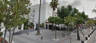 a street with trees in front of a building at Apartamento La Paz in Sanlúcar de Barrameda
