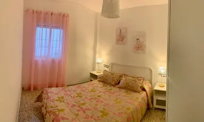 a small bedroom with a bed and a window at Apartamento La Paz in Sanlúcar de Barrameda