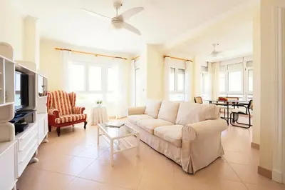 a living room with a white couch and a table at Summerlandrota La Caleta in Rota