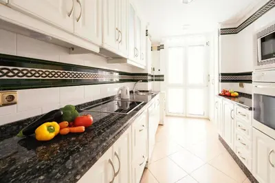 a kitchen with a counter with fruits and vegetables on it at Summerlandrota La Caleta in Rota