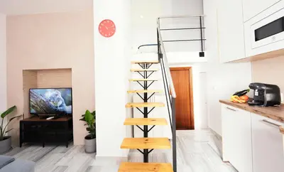 a spiral staircase in a kitchen with a living room at Summerlandrota Veracruz28 in Rota