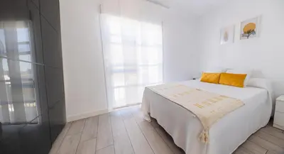 a white bedroom with a bed and a window at GuestReady - La Ostra in Novo Sancti Petri