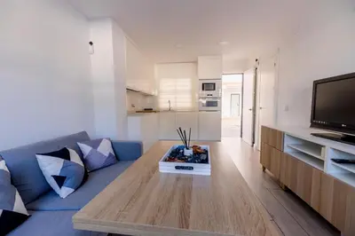 a living room with a blue couch and a tv at GuestReady - La Ostra in Novo Sancti Petri