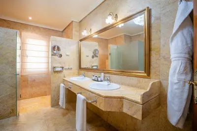 a bathroom with a sink and a mirror and a shower at Soho Boutique Duques de Medinaceli - Adults Recommended in El Puerto de Santa María
