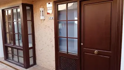 a pair of glass doors next to a building at Apartamentos Jasmund - Bungalow 119 in San Fernando