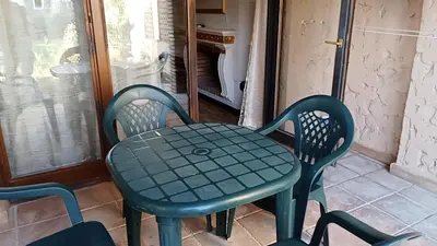 a green table and chairs on a porch at Apartamentos Jasmund - Bungalow 119 in San Fernando