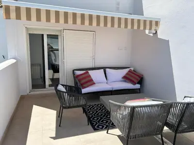 a patio with a couch and chairs and a table at Novo Sancti Petri in Cádiz