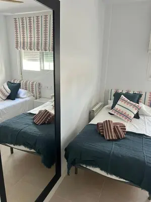a mirror reflection of a bedroom with a bed and a mirror at Novo Sancti Petri in Cádiz