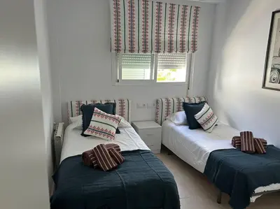 a bedroom with two beds and a window at Novo Sancti Petri in Cádiz