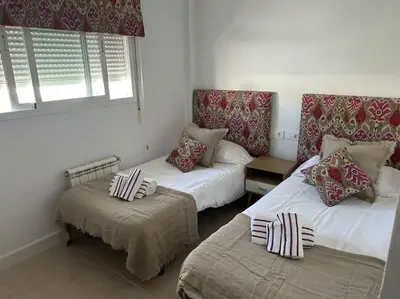 a room with two beds and a couch and a window at Novo Sancti Petri in Cádiz