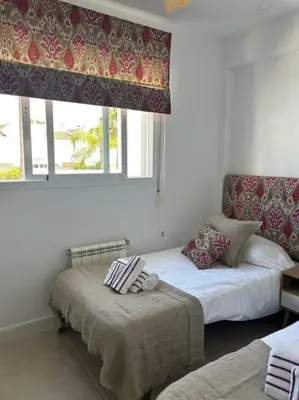 a bedroom with two beds and a window at Novo Sancti Petri in Cádiz