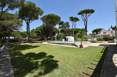 a large yard with a swimming pool and trees at Chici - Holiday Chiclana in Chiclana de la Frontera