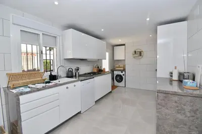 a large white kitchen with white cabinets and appliances at Chici - Holiday Chiclana in Chiclana de la Frontera