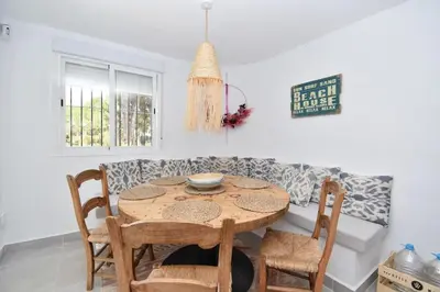 a table and chairs in a living room with a couch at Chici - Holiday Chiclana in Chiclana de la Frontera