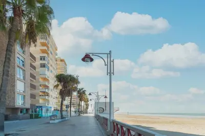 a street light on a sidewalk next to the beach at Disfruta Vacaciones Familiares Piso Frente al Mar in Cádiz