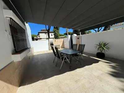a patio with a table and chairs on a balcony at Chalet con piscina in Chiclana de la Frontera
