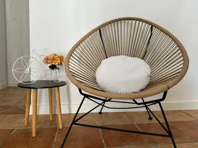 a chair with a white pillow sitting on a table at Chalet con piscina in Chiclana de la Frontera