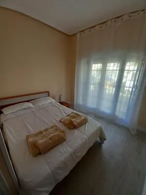 a bedroom with a white bed with two towels on it at Apartamento Centro Estación, Parking Privado in El Puerto de Santa María