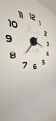 a white clock with black numbers on a wall at Casa Plaza Alta in Alcalá de los Gazules