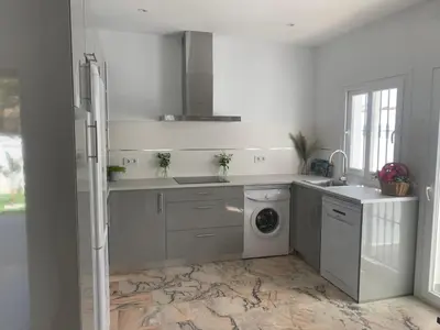a white kitchen with a washing machine and a washer at Chalet junto a la playa en Costa Sancti Petri in Chiclana de la Frontera