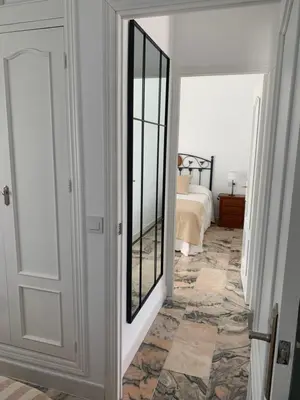 a hallway with a mirror and a bed in a room at Chalet junto a la playa en Costa Sancti Petri in Chiclana de la Frontera