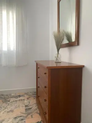 a dresser with a mirror and a vase on it at Chalet junto a la playa en Costa Sancti Petri in Chiclana de la Frontera
