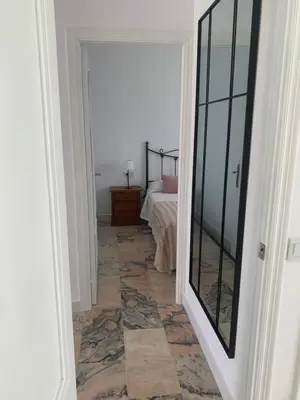 a hallway with a room with a bed and a mirror at Chalet junto a la playa en Costa Sancti Petri in Chiclana de la Frontera