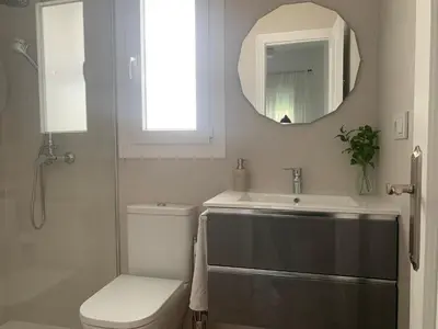 a bathroom with a toilet and a sink and a mirror at Chalet junto a la playa en Costa Sancti Petri in Chiclana de la Frontera