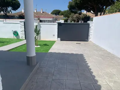 a driveway with a gate in a white fence at Chalet junto a la playa en Costa Sancti Petri in Chiclana de la Frontera