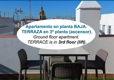 a table with chairs and a sign that readsarmaarmaarma an plantarmaaba at BRUJULA ground floor indoor apartment by Cadiz4Rentals in Cádiz