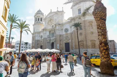 a group of people walking in front of a church at BRUJULA ground floor indoor apartment by Cadiz4Rentals in Cádiz