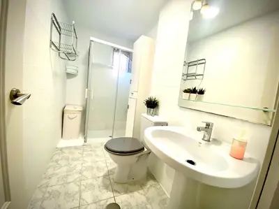 a white bathroom with a toilet and a sink at MyChoice San Francisco in Rota
