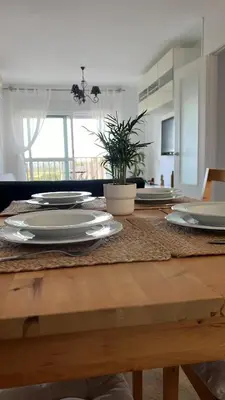 a dining room table with plates and a plant on it at La Bahía playa in El Trocadero