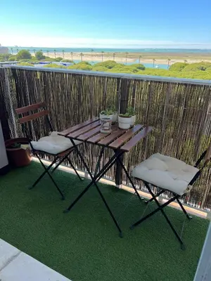 a table and two chairs on a balcony with the beach at La Bahía playa in El Trocadero