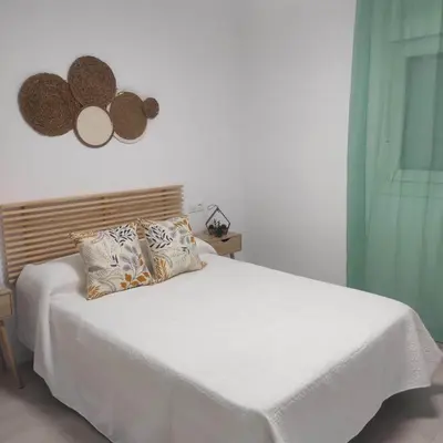 a bedroom with a white bed with a pillow at Ohana 2 in San Fernando