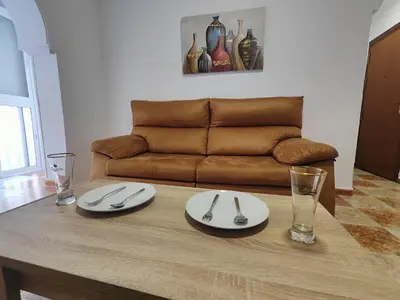 a living room with a table with a couch at Apartamento Playa Tanguillos del Mar in Cádiz