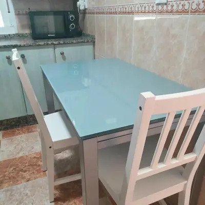 a blue table and a white chair in a kitchen at Apartamento Playa Tanguillos del Mar in Cádiz