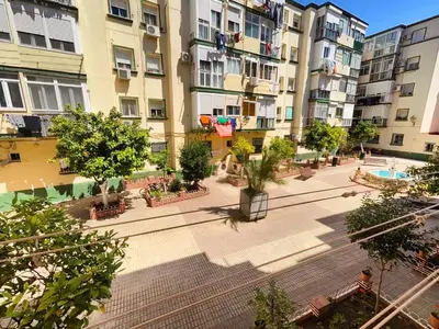 an apartment complex with a courtyard with trees and buildings at Apartamento Playa Tanguillos del Mar in Cádiz