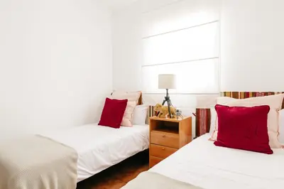 two beds in a room with red pillows at Fabiana in Chiclana de la Frontera