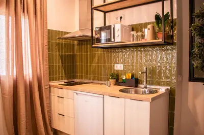 a small kitchen with a sink and a shower at Apartamentos Ribera del Rio 36 in El Puerto de Santa María