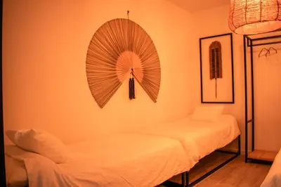 a room with two beds and a fan on the wall at Apartamentos Ribera del Rio 36 in El Puerto de Santa María