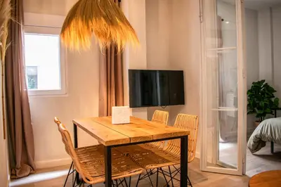 a dining room with a table and chairs and a tv at Apartamentos Ribera del Rio 36 in El Puerto de Santa María